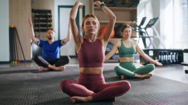 Barışçıl grup birlikte yoga meditasyonu yapıyor spor minderinde bacak bacak bacak üstüne atarak oturuyor. Kapalı gözlü kadın koç Lotus 'a klas pozlar veriyor. Yogi halkı meditasyon yaparken...... farkındalık ve sakinlik hissediyorlar..