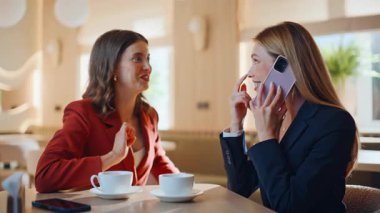 İki başarılı bayanın birlikte oturduğu lüks restoranda keyifli bir telefon konuşması. Gülümseyen iş kadınları cep telefonundan sonra beş kez konuşuyor. Mutlu iş ortakları cep telefonu konuşmasından memnun.
