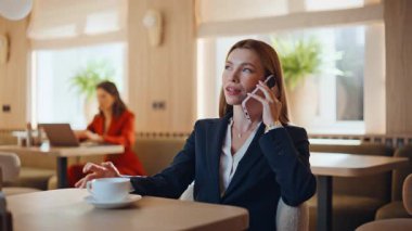 Kahve molasında cep telefonlu kafeteryadan konuşan kendine güvenen bir iş kadını. Başarılı kadın CEO tek başına kafedeki cep telefonunu arıyor. Lokantada akıllı telefonla pazarlık yapan zarif bir bayan.