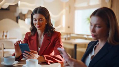 İki başarılı kadının cep telefonlarıyla mesajlaşması rahat bir kahvehanenin kapanmasına neden oldu. Modern restoranda akıllı telefonlara mesaj atan zarif iş kadınları. Kafeteryada cep telefonlarını kaydıran kendinden emin meslektaşlar.