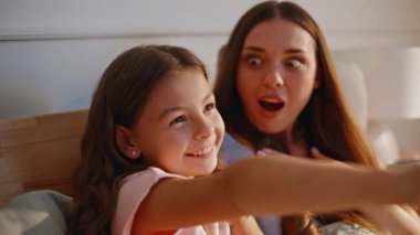 Modern odada kucaklaşan tatlı bir anne çocuğu. Genç anneye bağlanan komik esmer kız hafta sonunu rahat, aydınlık yatak odasında geçiriyor. Küçük çocuk güneşli evde kadın ebeveyni kucaklıyor. Aile kavramı