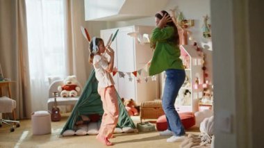 Anne çocuğu evde müzikten zevk alıyor. Annesiyle eve atlayan aşırı neşeli kız çocuk. Neşeli kız ve kulaklıklı anne birlikte dans edip, en sevdikleri şarkıları dinliyorlar. Mutlu yaşam tarzı konsepti