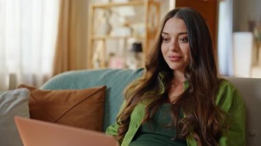 Startuper parmak dokunmatik pedi, evdeki kanepede oturuyor. Heyecanlı kadın serbest çalışan bilgisayar uzmanı apartman kanepesinde proje yaratıyor. Şaşırtıcı kazanan el kol hareketi yaparak başarıyı kutluyor.