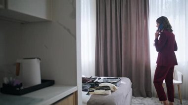 Kahve fincanı ile otel yatağında oturan başarılı bir bayan cep telefonuyla konuşuyor. Lüks yatak odasının içinde gülümseyen bir iş kadını cep telefonunu arıyor. Giriş yaptıktan sonra akıllı telefondan konuşan zarif kadın turist..