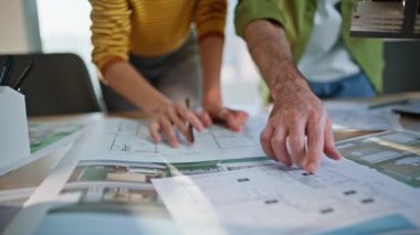 İç mimarlar, iş yerindeki planlama binasını yakından inceliyor. Odaklanmış Afro-Amerikan kadın, planı analiz ediyor. Mimari tasarımı koordine eden proje tartışılıyor..