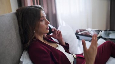 Otel misafiri yataktan arıyor. İş görüşmelerini yakın plan yapıyorlar. Zarif takım elbiseli ciddi bir iş kadını rahat beyaz bir yatakta cep telefonuyla konuşuyor. İş gezisinde başarılı bir bayan buluşma ayarladı.