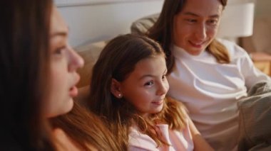 Güneşli yatak odasında uzanmış ebeveynler hakkında konuşan komik çocuk. Çeşitli pozitiflikte anne baba hafta sonu sabah birlikte dinlenen kızını dinliyor. Anne ve babayla iletişim kuran küçük bir kız. Aile kavramı