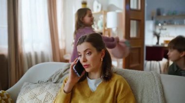 Serbest çalışan bir kadın cep telefonundan konuşuyor. Yaramaz çocuklar oturma odasını kapatıyor. Sinirli anne iş kadını akıllı telefon görüşmesi yapıyor. Aktif küçük çocukların oynaşmasından rahatsız oluyor.