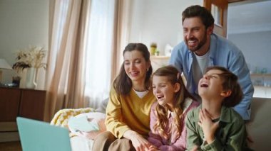 Neşeli akrabalar evdeki bilgisayarları arıyor. Pozitif insanlar internette sohbet ediyorlar. Akrabalarına el kol hareketi yapıyorlar. Gülümseyen aile dairedeki sanal arama sırasında dizüstü bilgisayara bakıyor