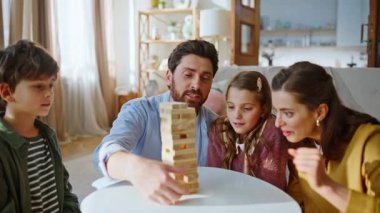 Aile oyunu oynuyor, hafta sonu sessiz sakin bir daire kapanışı. Tahta blokları istifleyen heyecanlı akrabalar kahkahalar atıyor. Mutlu ebeveynler, genç kızlar, küçük oğlan birlikte kule inşaatının keyfini çıkarıyor.