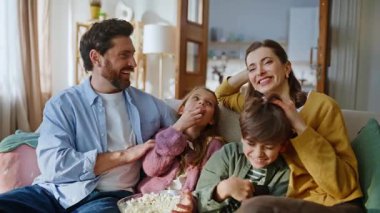 Anne ve babalar televizyon seyredip, kanepeyi kapatıyorlar. Gülümseyen anne baba, sevimli küçük çocuklarla bağ kuruyor ve birlikte komik bir film izliyorlar. Gülen akrabalar video bloglarında eğleniyorlar.