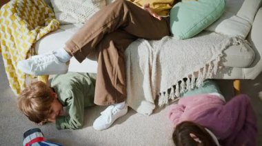 Kardeş saklanıyor, kanepenin altında oynuyor. Anne iş kadını akıllı telefon görüşmesi yapıyor. Yaramaz çocuklar gürültü odası yapıyorlar. Freelancer anne konuşuyor. Cep telefonu tepkisi çocuklara bağırıyor.