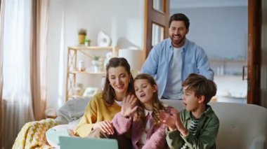 İnternetteki sıcak apartman toplantısında internet kameralı çocukların akrabalarını selamlaması. Neşeli sakallı baba sanal sohbete katılıyor. Mutlu aile uzaktan konuşuyor. Teknoloji konsepti