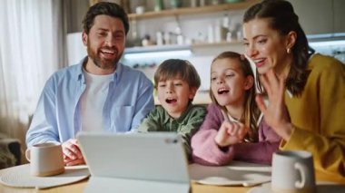 Sabah aile selamı videosu rahat bir apartman dairesine yakın çekim. Pozitif aile, internet bağlantısı tableti ev mutfağı kullanarak akrabalarıyla çevrimiçi görüşüyor. Modern teknoloji