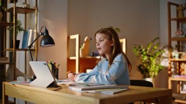 Öğrenci çevrimiçi derslere cevap veriyor. Evde yakından ders çalışıyor. Çalışkan liseli kız okul web sayfası görüntüsü tablet web kamerasından bilgi defterine not alıyor. Uzaktan eğitim bilgisi kazanma.