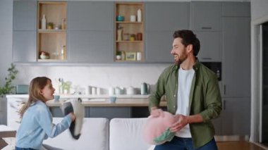 Mutlu baba, küçük kız hareketli eğlenceli oyun evini oynuyor. Gülümseyen genç sakallı adam yastıklarla savaşıyor kızı hafta sonunu birlikte geçiriyor. Neşeli baba, ergen çocuk eğleniyor..