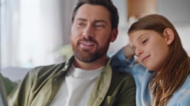 Rahat baba tablet araklıyor ve sevimli küçük kızıyla internet içeriği izliyor. Gülümseyen sakallı adam kaygısız kız internette bilgisayar uygulaması kullanarak rahat koltukta alışveriş yapıyor.