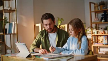 Mutlu baba, akıllı ortaokul öğrencisiyle ev ödevlerini tartışıyor. Gülümseyen baba, görevini tamamlayan kızını över. Ebeveyn desteği ev uzaktan eğitim