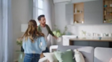 Modern oturma odasında koşan oyuncu bir kız çocuğu. Mutlu ergenlik çağındaki kızlar eğleniyor gülümseyen babalar aile içi hafta sonlarını birlikte geçiriyorlar. Neşeli adam, küçük hanım gülüyor..