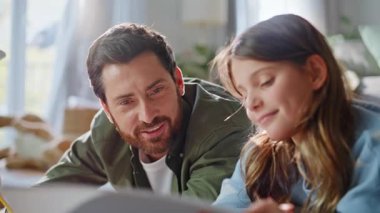 Gülümseyen adam kızını çiziyor. Yaratıcı ev hobisi. Yakın plan. Mutlu sakallı baba. Sevimli çocuk. Renkli pastel boyalarla çizim yapıyor. Aile sanatı yaratıcılığı ilham verici..