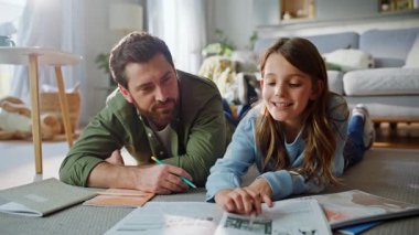 Baba kızına okul dersinde yardım ediyor. Dairenin zeminini birlikte kapatıyoruz. Gülümseyen sakallı adam ödevlerini yaparken ders kitabı okuyan akıllı kız konuşuyor. Çocuk eğitim desteği.