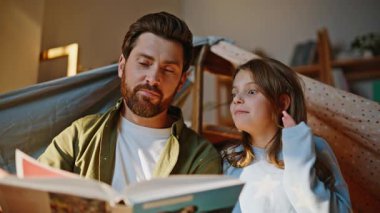 Baba çocuk masal anlatmanın keyfini çıkar battaniye kalesi yakın çekim. Hasta baba kitap okuyan kız ilginç bir roman okudu. Mutlu, rahat aile sayfalarını çeviriyor, birlikte hikaye paylaşıyoruz.