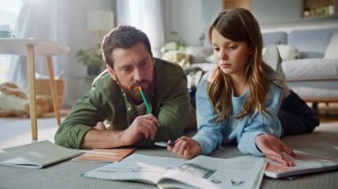 Baba kız okul ödevlerini çözüyor ders kitaplarına bakıyor daire zeminini birlikte kapatıyoruz. Önemseyen baba, küçük kız ev ödevi yaparak eve dönüş dersi veriyor. Ebeveyn desteği öğrenci bilgisi kazanılıyor.