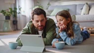 Baba kız tablet seyrediyor, apartman zeminini kapatıyorlar. Mutlu sakallı baba, ergenlik çağındaki kızın eğitim videolarına göz attığını söylüyor. Dijital içerik, aile bağları, eğlence....