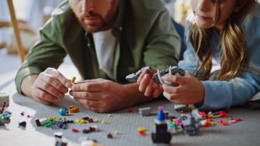 Baba çocuk inşaat yapıyor, apartman zeminini kapatıyor. Mutlu baba, sevimli kız hafta sonu evde yaratıcı lego blokları da dahil. Sevgi dolu baba, tatlı küçük kızı oynuyor. Babalığın tadını çıkar.