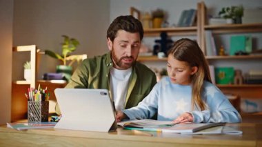 Babası online destek veriyor ve genç kızı yakından inceliyor. Okul ödevini açıklayan sakallı adam. Tablet bilgisayarla evde oturan zeki kız öğrenci. Uzaktan eğitim.