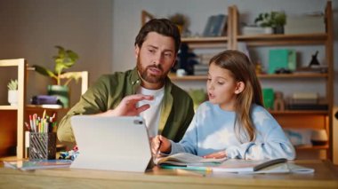 Baba, internet dersinde birlikte oturan kızına yardım ediyor. Önemseyen baba, tablet arayan eğitimci kız öğrenciyi anlatıyor. Uzaktan çalışmada babasına destek olan çocuk..