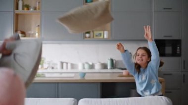 Çocuk babası yastık fırlatan bir apartman dairesi. Mutlu küçük kız komik oyun oynuyor sakallı baba evde vakit geçiriyor. Gülümseyen ebeveyn çocuk birlikte eğlenmeyi sever.
