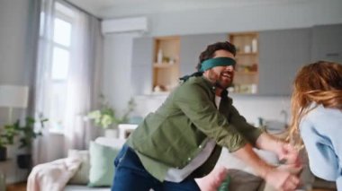 Saklambaç oynayan kız evde mutlu sakallı bir baba arıyor. Gözleri bağlı bir adam neşeli bir çocuk yakalıyor. Aktif aile eğlencelerinin tadını çıkarıyorlar. Birlikte eğleniyorlar. Neşeli güzel kız koşuyor gülüyor.