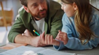 Baba kız evde oturma odası zeminine yakın çekim yapıyor. Okuldaki sakallı babayı açıklayan tatlı küçük kız çocuğu. Gülümseyen zeki bir adam liseli kızı öpüyor ödev yapmayı düşünüyor.