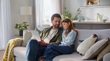 Baba çocuk video tabletini karıştırıyor rahat kanepeyi birlikte rahatlatıyor. Gülümseyen sakallı baba rahat, rahat, rahat koltukta oturan kızına internetten ders veriyor. Mutlu modern aile bağları.