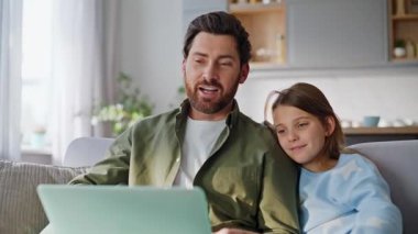 Erkek kız video karşılaması rahat koltukta otururken yakın çekim. Pozitif ailelerin internet bağlantılarıyla ev oturma odasında internet üzerinden akrabalarıyla görüşmeleri var. Modern web teknolojisi.