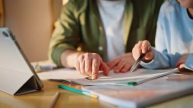 Baba parmağı, küçük kızıyla birlikte ev ödevi yaptığını gösteriyor. Zeki adam okul kızının tablet daire masasına göz atmasını açıklıyor. Ev uzaktan eğitim desteği.