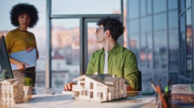 Kadın yönetici, inşaat şirketinde yönetici olarak çalışıyor. Afrikalı Amerikalı patron dizüstü bilgisayarla mimarla projeyi tartışıyor. Mimari tasarım konusunda çok ırklı mühendisler işbirliği yapıyor.