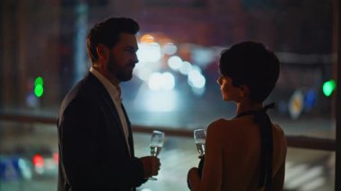 Siluet aşk çifti, şehrin aydınlanmış panoramik otelinde birlikte çıkıyorlar. Sevecen bir adam büyük pencerelerde sevgili arıyor. Kutlama yıldönümünde mutlu bir çift gözlük.