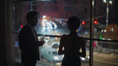 Akşam çifti panoramik lüks otel manzarasıyla çıkıyorlar. Yakışıklı adam şampanya kadehlerini modern oturma odasına getiriyor. Sevecen bir çift ayakta içki içiyor. Sevgililer yıldönümünü kutluyor