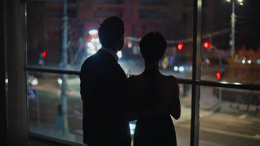 Gece aşıkları şehir manzarasına bakıyor yıldönümü manzarasını kutluyorlar. Aşk çifti, şehrin arka planında yakın planda buluşarak vakit geçiriyorlar. Romantik insanlar akşam oteli. Zarif çift bakışlı pencere