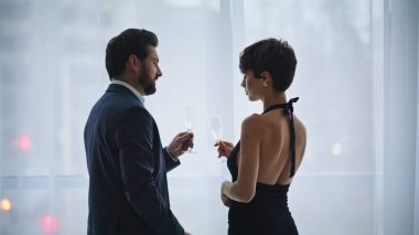 Romantik aşıklar şehir manzarası hakkında konuşuyor. Otelde alkolü yudumluyorlar. Şarap kadehlerini birbirine çarpıştıran panoramik pencerelerde buluşan zarif çift. İki eş sakin bir konuşma yapıyor. Nazik bir adam ve bir bayan