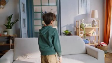 Neşeli, genç bir anneye oyuncak atan oyuncu bir çocuk. Açık renkli oturma odasının içinde birlikte oyun oynuyorlar. Mutlu enerjik anne çocuğu etrafta aylak aylak dolaşırken aile hafta sonu evinin keyfini çıkar. Ebeveyn sevgisi