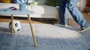 Baba bacakları tekmeliyor. Küçük oğluyla futbol oynuyor. Oturma odasını kapatıyor. Mutlu baba çocuk evde futbol maçının tadını çıkarıyor. Çocukluk çağındaki oyuncu çocuk babasıyla vakit geçiriyor..