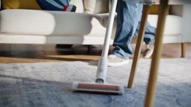 Önemseyen baba yerleri süpüren çocuk yastık fırlatıyor gülümseyen adamı ev temizliğinden alıkoyuyor. Neşeli baba, ev işi yapan sevimli küçük çocuğu oynuyor. Aile içi eğlence.