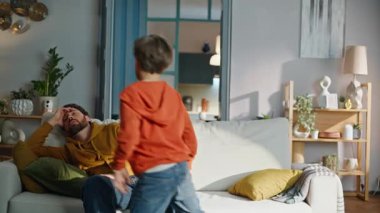 Bekar bir baba, oturma odasında koşuşturup, rahatsız edici, mutsuz, genç bir adamın kanepede oturmasından rahatsız oluyor. Üzgün sakallı baba stres altında başını tutuyor. Babalık rutini.