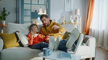 Baba çocuk televizyon programını tartışıyor rahat koltukta oturup patlamış mısır yiyor. Sevimli küçük çocuk sakallı adam abur cuburların tadını çıkarıyor. Mutlu çocuk, bekar baba birlikte televizyon izliyor..