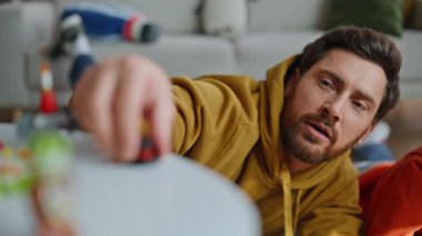 Baba, sevimli oğlunla oynamaktan zevk alıyor. Dairenin zeminini kapatıyorlar. Değer veren sakallı adam plastik blokları alıp sevimli çocuğun oyuncak hayvan yapmasına yardım ediyor. Mutlu aile yaratıcı oyun zamanı harcıyor.