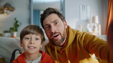 Pov videolu baba konuşuyor, kamera dairede oturuyor, kanepe kapanıyor. Gülümseyen duygusal baba oğul el sallayan web kamerası videosu. Mutlu ve rahat bir aile. Keyifli internet iletişimi..