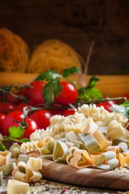 Three-color pasta in the shape of hearts on a wooden table